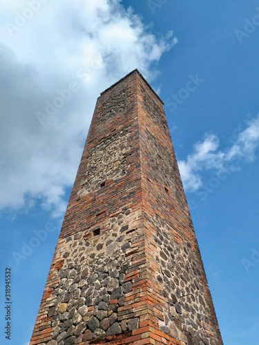 Old sugar mill chimney in sugarcane plantation