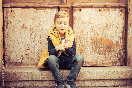 Cute boy relaxing on steps outdoors. © LumineImages