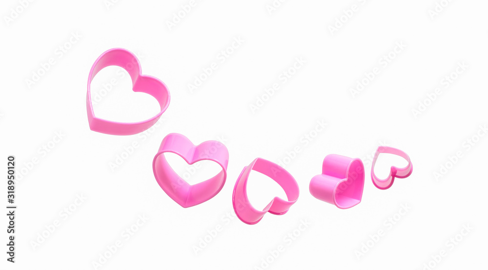 Set of five pink hearts molds of different size levitate on white backdrop. Plastic dough cutters or forms for gingerbread cookies. Isolated objects.
