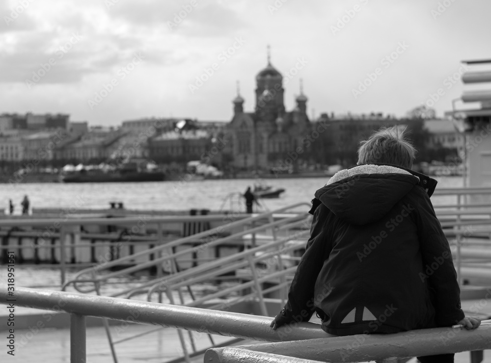 the child on the railing by the river looks into the distance the child on the railing by the river looks into the distance