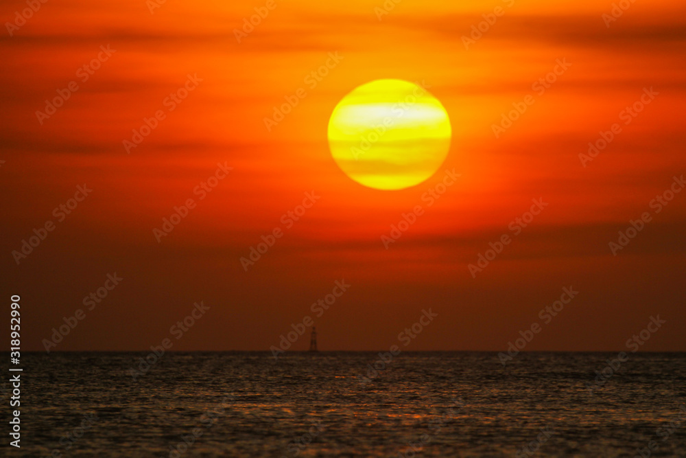 Sea buoy in the ocean on a sunset background