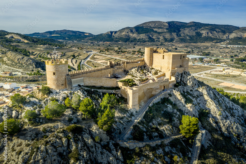 Aerial view of Castalla castle in Valencia province Spain with donjon towering over the town and a courtyard reinforced with a circular tower on a sunny day with blue sky ground plan