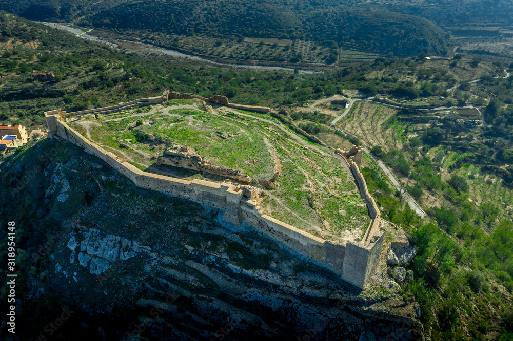 Aerial view of Cervera de Maestre castle with ruined excavated inner building remains surrounded by a partially restored outer wall of Arab origin