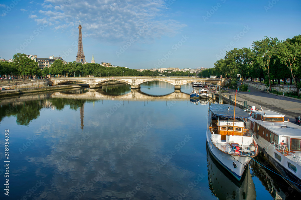PARIS, FRANCE - MAY 26, 2018: View of the Bridge of the Invalides and the Eiffel Tower. Walk through Pont Alexandre III. Boats on the pier