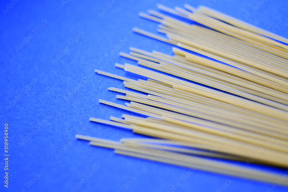 raw spaghetti on blue background raw spaghetti on blue background