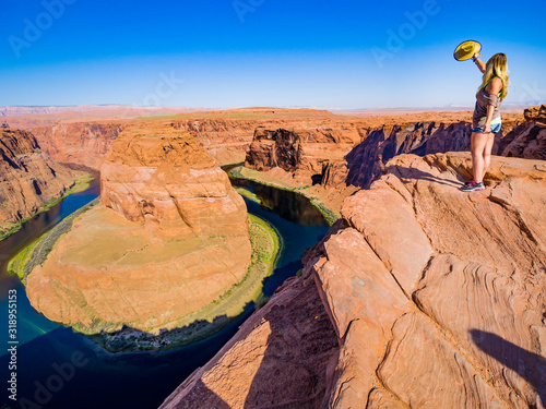 Sexy girl admires panorama of Horseshoe Bend, Page Arizona, the Colorado River and mass made of sandstone, has become major tourist destination.