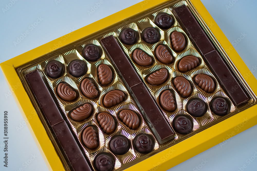 Assorted chocolate candies in yellow box. Assorted chocolate candies in yellow box.