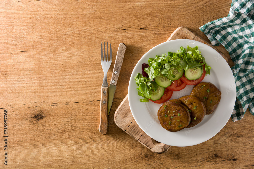 Seitan with vegetables on wooden table top view copy space. Fake meat Seitan with vegetables on wooden table top view copy space. Fake meat