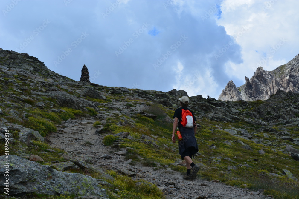 randonneur montant vers un col et un cairn