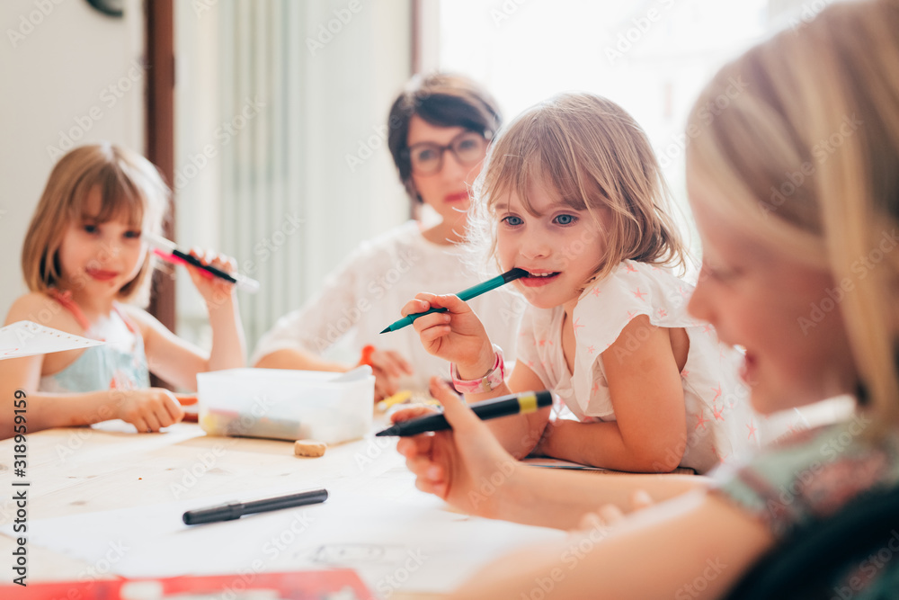 three female siblings children indoor drawing on a paper - playing, drawing activities, creativity concept three female siblings children indoor drawing on a paper - playing, drawing activities, creativity concept