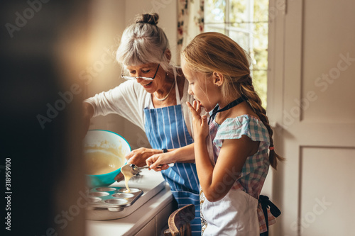 Foto Granny and kid making cup cakes