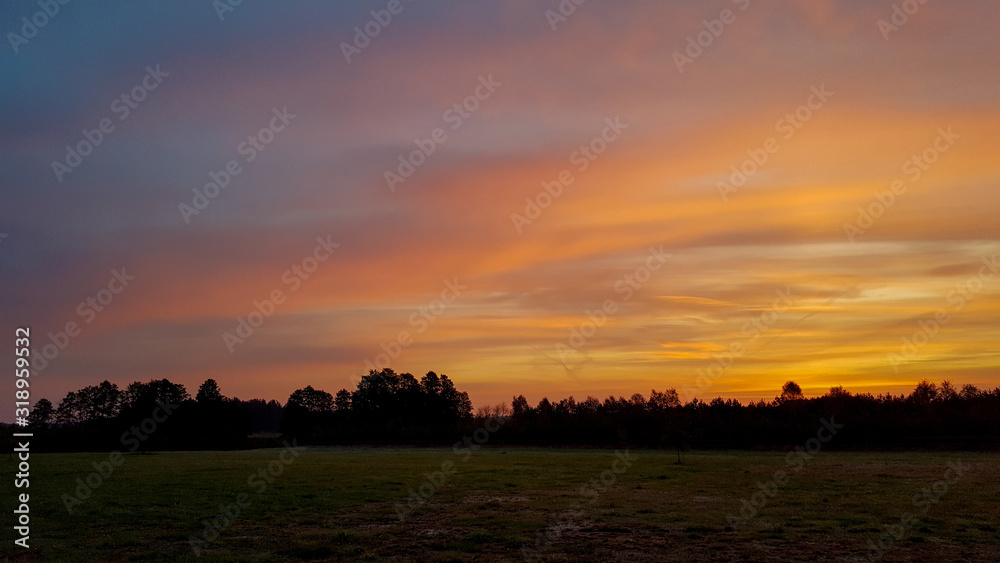Beautiful sunset on a large meadow in the middle of nowhere in Poland, Europe