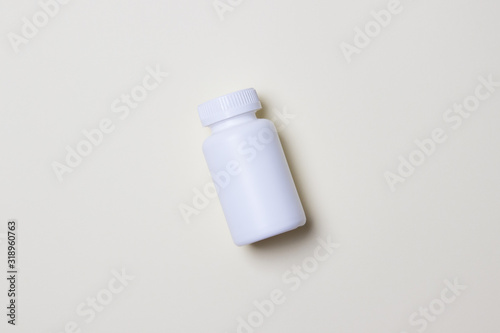 White plastic medical container for pills on yellow colored paper background