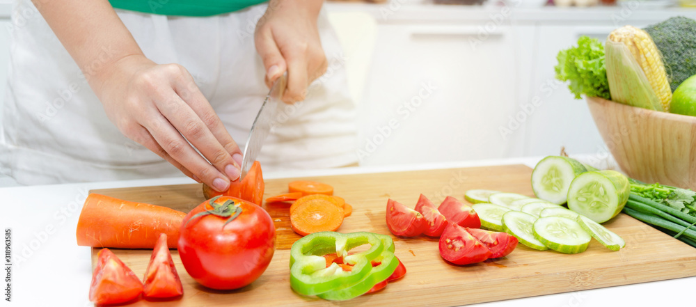 Banner. young pretty woman in green shirt cutting cooking and knife preparing fresh vegetables salad for good healthy in kitchen at home, healthy lifestyle, cooking, healthy food and dieting concept Banner. young pretty woman in green shirt cutting cooking and knife preparing fresh vegetables salad for good healthy in kitchen at home, healthy lifestyle, cooking, healthy food and dieting concept