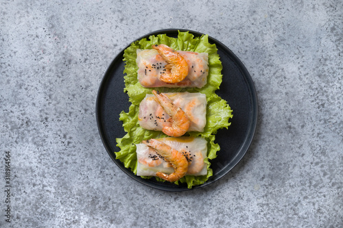 Vietnamese food spring rolls with shrimps in rice paper on grey. View from above. Asian cuisine. Horizontal orientation.