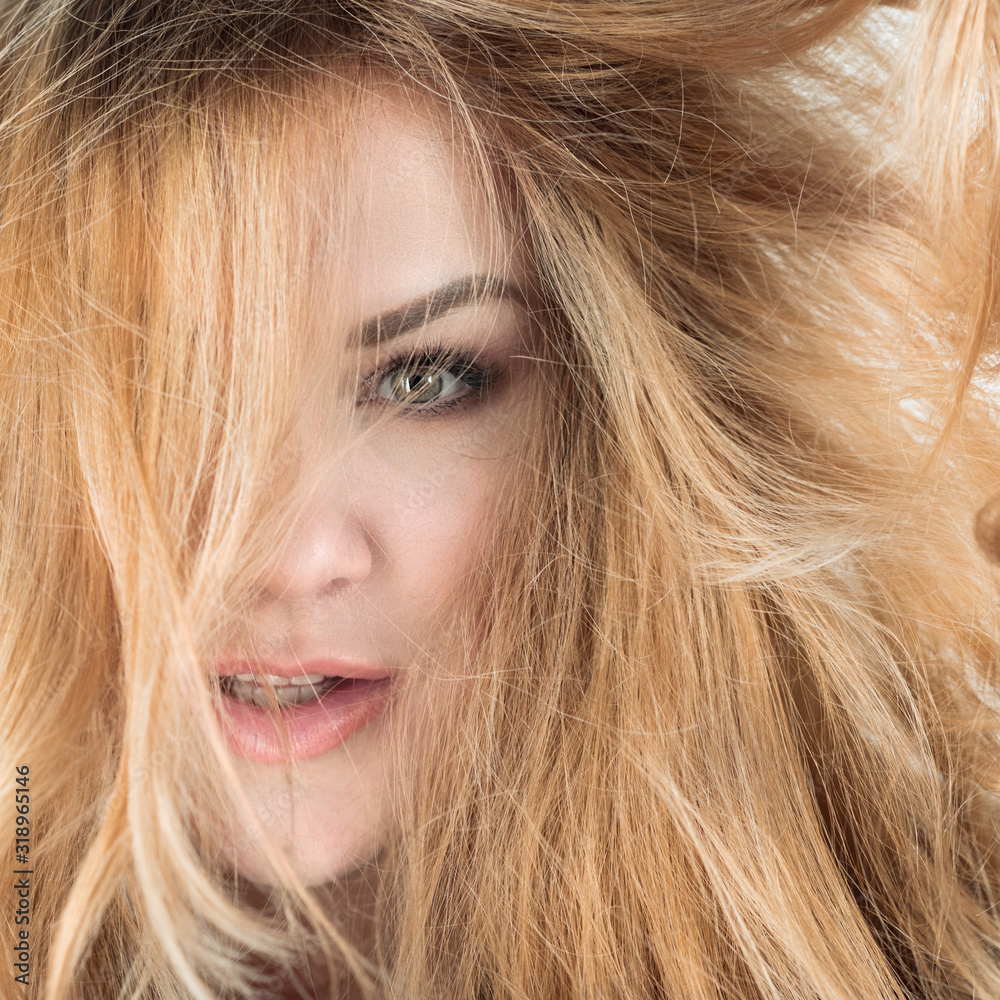 Closeup portrait of blond woman with face surrounded by golden hair - square format Closeup portrait of blond woman with face surrounded by golden hair - square format
