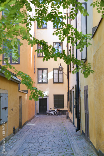 Narrow cobblestone street with a bicycle and yellow medieval houses of Gamla Stan historic old center of Stockholm  Sweden