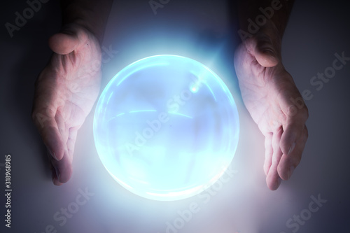 Magician or fortune teller is predicting future with crystal sphere. photo