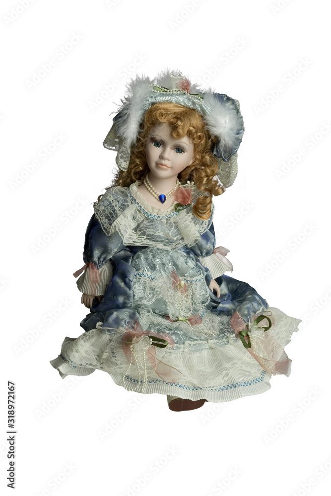 vintage doll isolated on white background - girl with curly hair in a hat and decorated dress