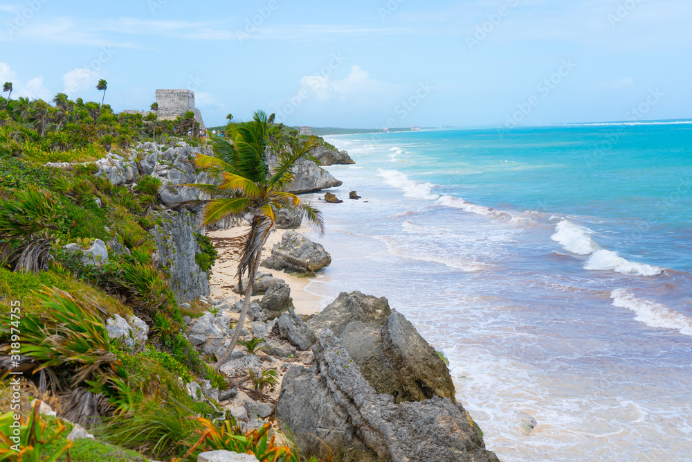 Ruins of ancient Tulum. Architecture of ancient maya. View with sea. Blue sky and lush greenery of nature. travel photo. Wallpaper or background. Yucatan. Mexico.