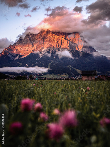 Colorful summer sunset after the storm. Zugspitze Mountain peak. Lermoos village in the Austrian Alps. Tirol, Europe. Magical nature landscape.