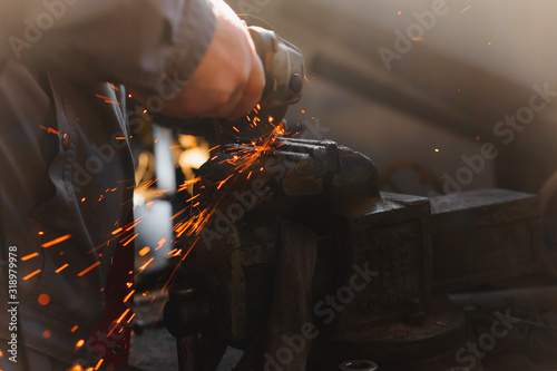 sawing metal. sparks frying over the working table during metal grinding