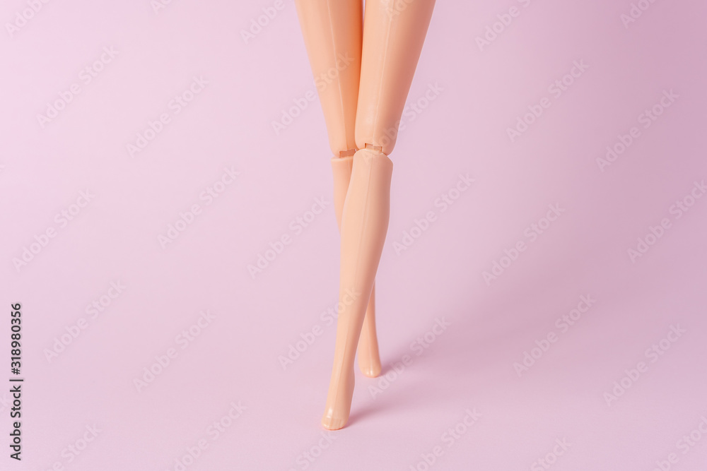 Doll legs on pink background. Creative minimal summer concept. Stock Photo  | Adobe Stock