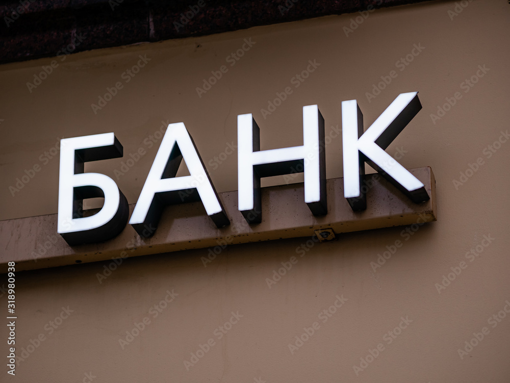 Backlit Bank sign above the entrance. Text in russian is Bank Backlit Bank sign above the entrance. Text in russian is Bank