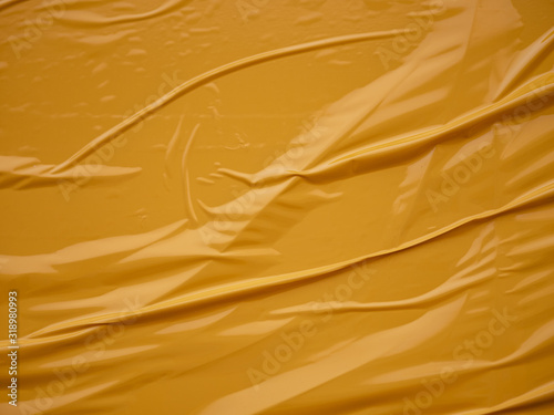 Yellow vinyl film overlapped pieces. Background from a film with a wavy texture glued to the surface