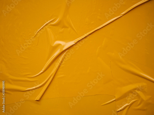 Yellow vinyl film overlapped pieces. Background from a film with a wavy texture glued to the surface photo