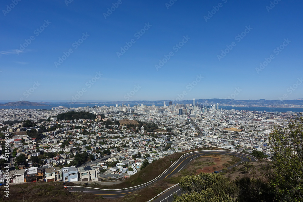 View of the San Francisco skyline with a windy road from Twin Peaks overlook