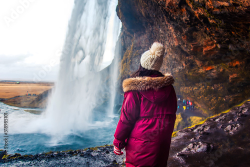 Fényképezés Woman enjoying visiting a waterfall view in Iceland