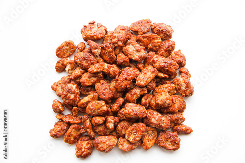 Nuts pile background. Sugar roasted pecan nuts (caramelized, praline nuts) in a glass on a white background, top view