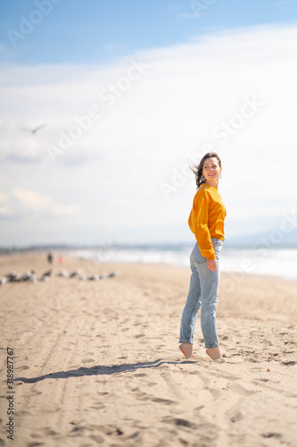 Young barefoot girl on the beach