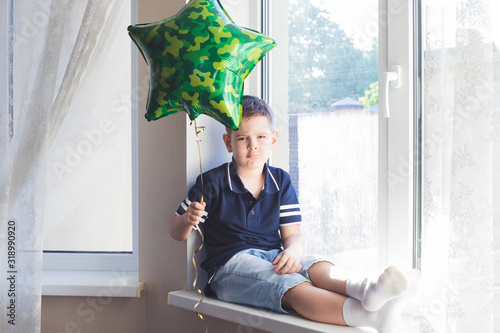 Funny boy sits on window. photo