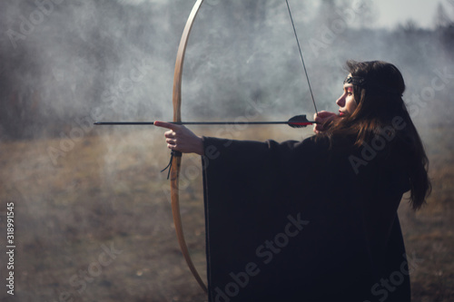 Warrior medieval woman with bow in battlefield