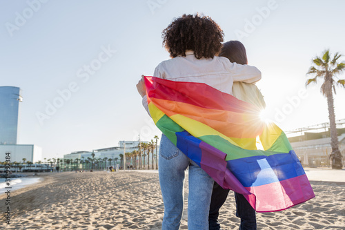 Photography couple of lesbian girls walk with a rainbow flag