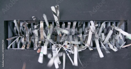 Close shot of paper being shredded through mechanical jaws