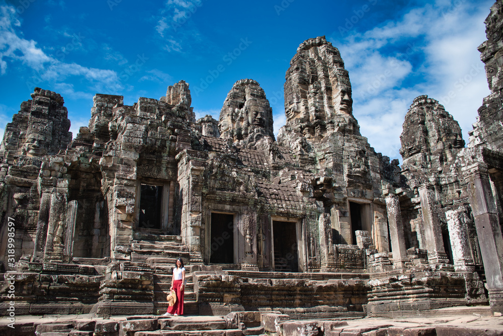 Beautiful, pretty, young Thai girl is exploring the ancient ruins of Angkor Wat (City/Capital of Temples) Hindu temple complex in Siem Reap, Cambodia. The largest religious monument in the world