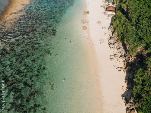 Aerial drone view of tropical island with white beach and blue clear water and jungle. Bali Indonesia. Tropical background and travel concept