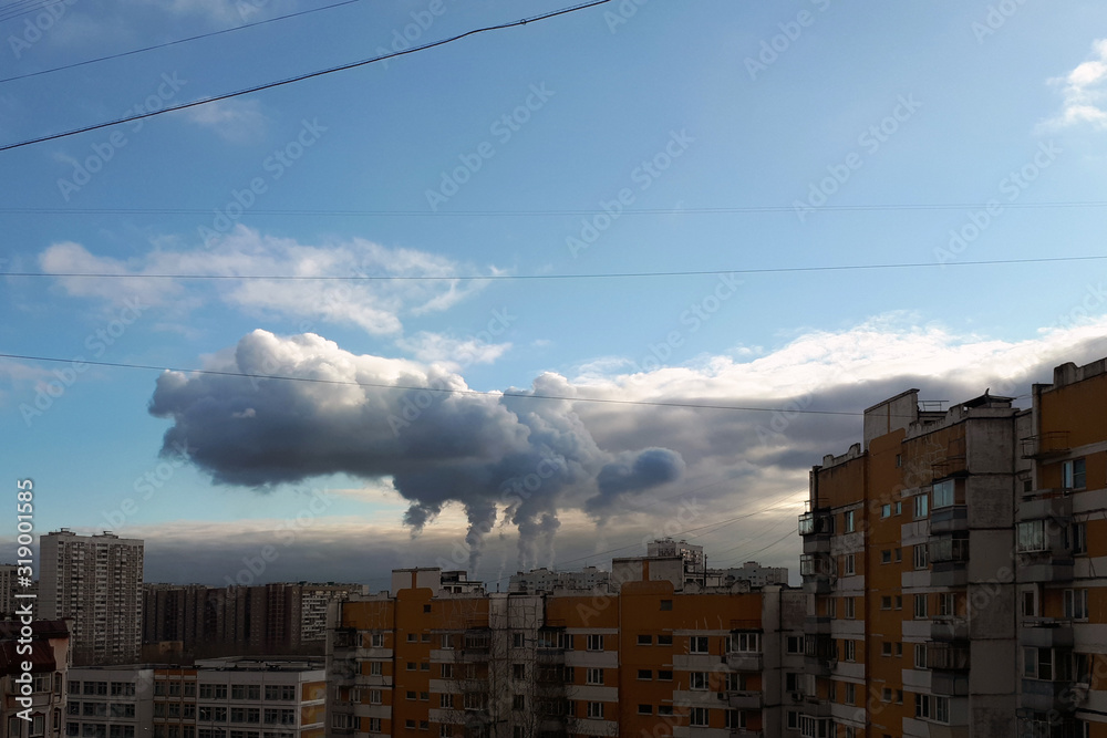 smoke from the chimney rises over the city into the sky