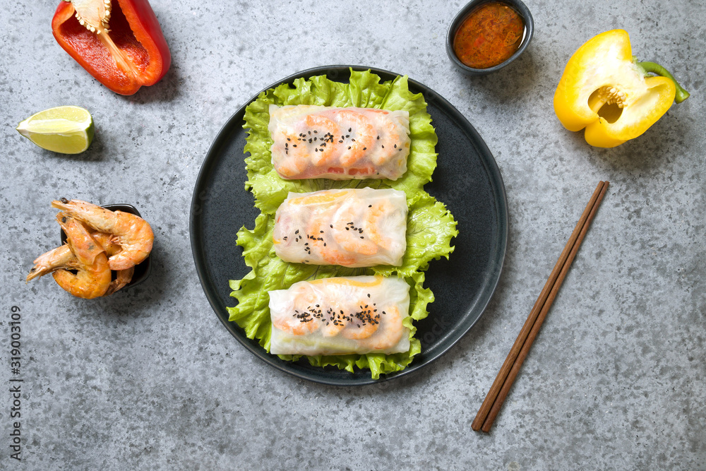 Vietnamese spring rolls with shrimps in rice paper on grey. View from above. Asian cuisine. Vietnamese spring rolls with shrimps in rice paper on grey. View from above. Asian cuisine.