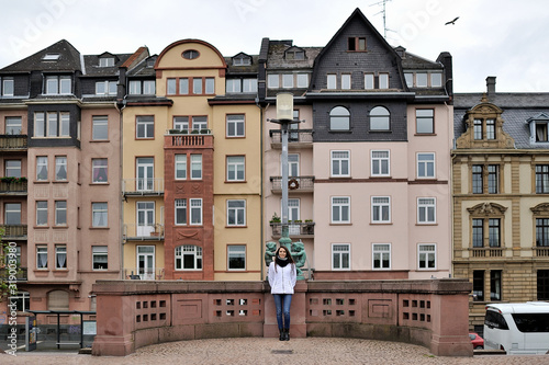 A tourist girl outdoors against the backdrop of the attractions of the city of Frankfurt am Main, Germany