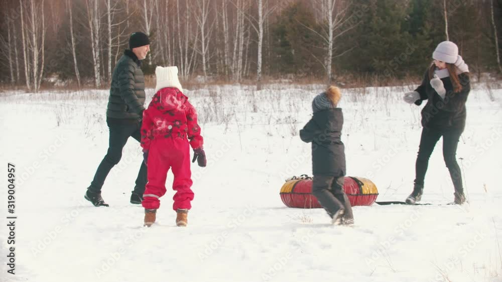 Family throwing snow on each other in winter time Family throwing snow on each other in winter time