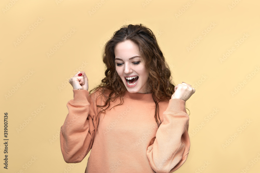 Portrait of a young beautiful woman wearing sweatshirt posing isolated over yellow background Portrait of a young beautiful woman wearing sweatshirt posing isolated over yellow background