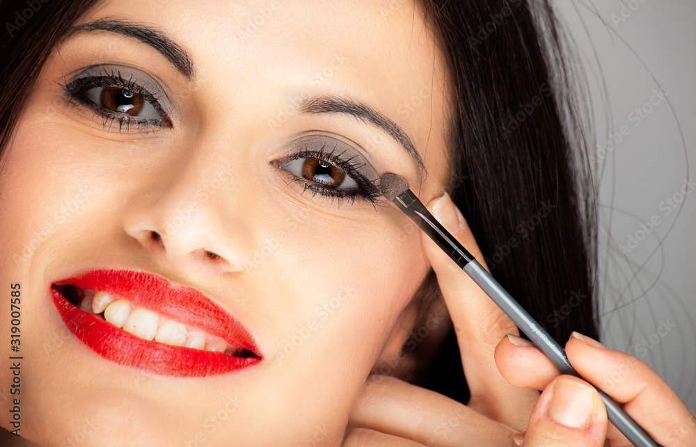 Young beautiful woman applying eyeliner on eyelid with pencil Young beautiful woman applying eyeliner on eyelid with pencil