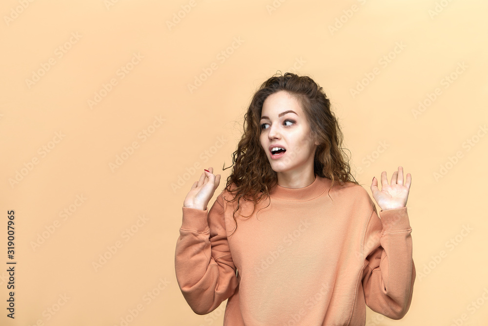 Portrait of a young beautiful woman wearing sweatshirt posing isolated over yellow background