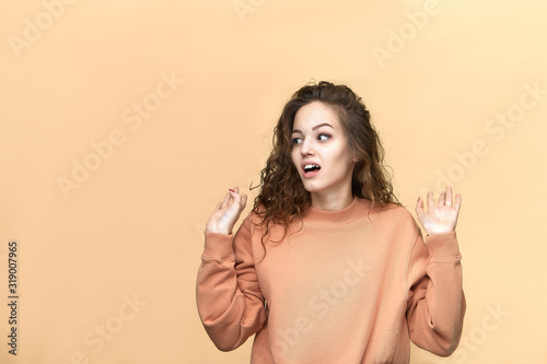 Portrait of a young beautiful woman wearing sweatshirt posing isolated over yellow background