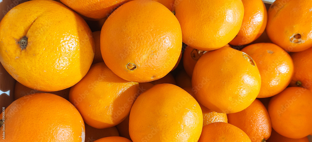 Orange citrus.Ripe, fresh, yellow oranges in baskets are sold in the grocery store market, fruits and vegetables. Lots of oranges. Food background. Orange citrus.Ripe, fresh, yellow oranges in baskets are sold in the grocery store market, fruits and vegetables. Lots of oranges. Food background.