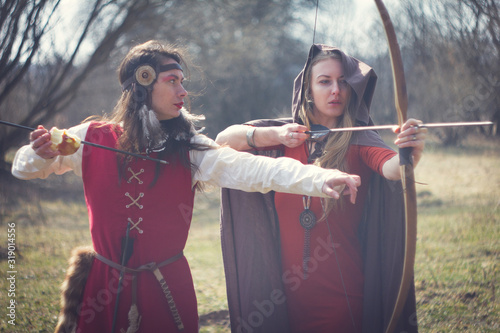 Girls dressed as medieval teaching archery at the field